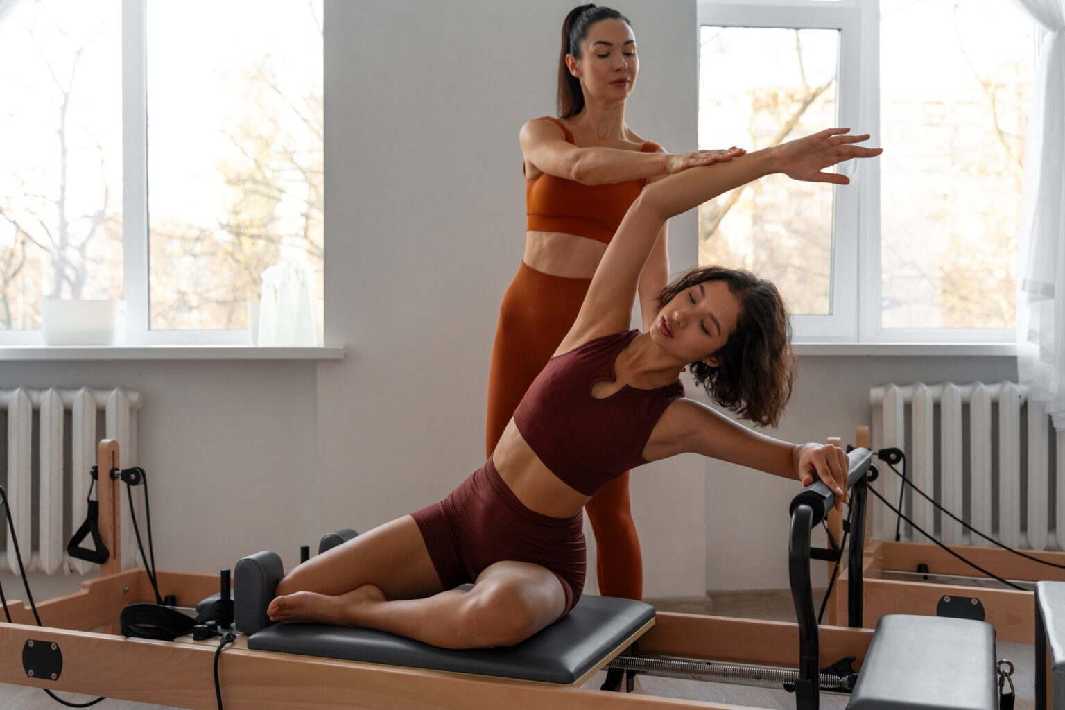 Alumno realizando un ejercicio de estiramiento en máquina Reformer.